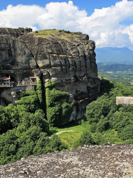 Meteora rock formations with monastery and cross, Greece, on Hidden Trails Hiking Tour.