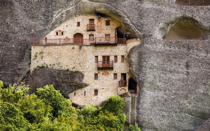 Monastery built into rock face on Hidden Trails of Meteora Hiking Tour, Greece.