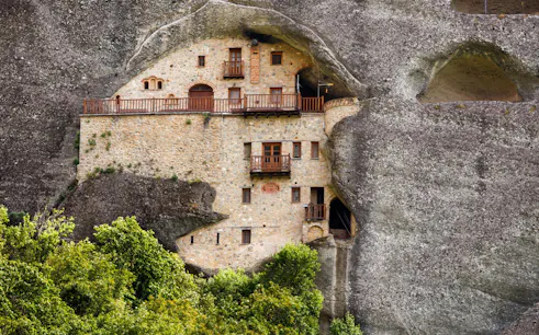 Monastery built into rock face on Hidden Trails of Meteora Hiking Tour, Greece.