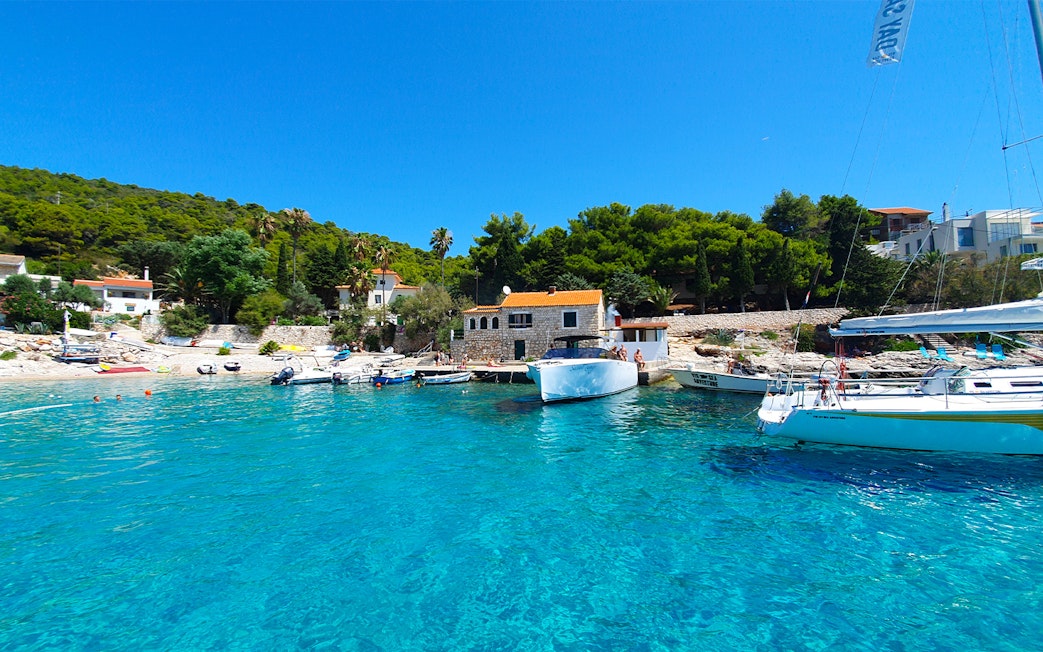 Boats docked at a scenic bay on the Split full-day tour to Blue Cave, Vis, and Hvar.
