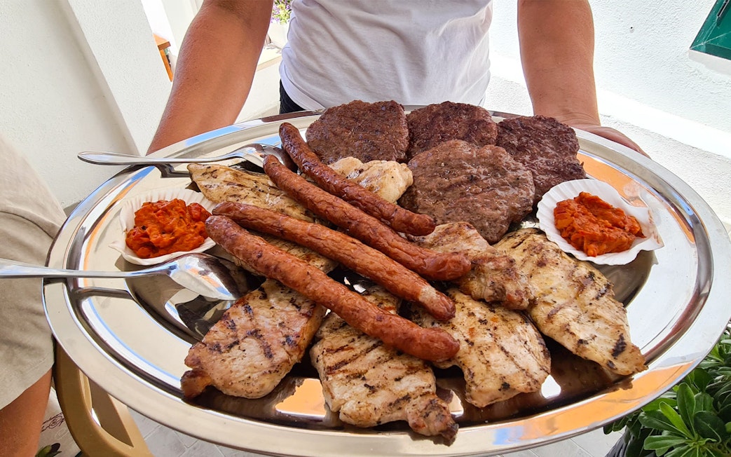 Grilled meats and ajvar served on a platter during Split boat tour lunch.