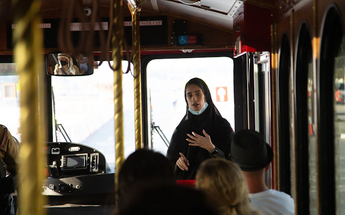 Tour guide speaking to passengers on a cultural bus tour.