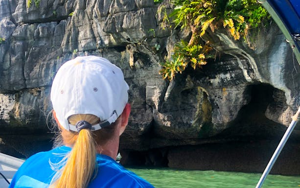 Person on a boat viewing limestone cliffs during Langkawi UNESCO Geopark Mangrove Discovery Tour.