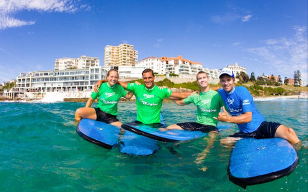 Surf instructors and students on surfboards at Bondi Beach, Sydney.
