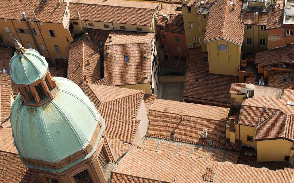 Aerial view of Bologna's historic rooftops and dome on Jewish walking tour.