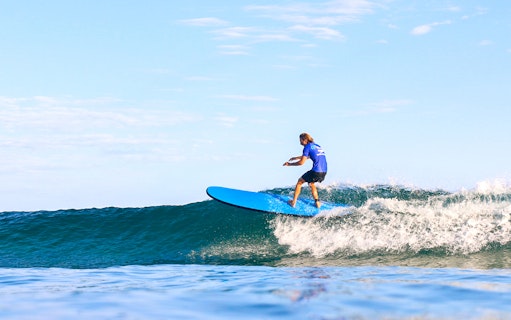 Surfer riding a wave during a lesson in Byron Bay, Australia.