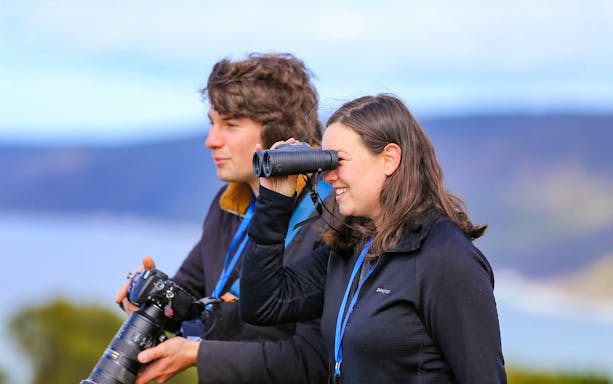 Tourists observing wildlife with binoculars on the Walk with Wildlife Guided Tour at Wildlife Wonders.