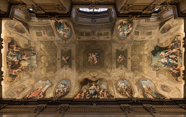 Ornate ceiling frescoes at the Theatre Museum, depicting classical figures and cherubs.