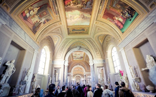 Vatican Museums corridor with ornate ceiling and sculptures, part of Full Rome Pass tour.