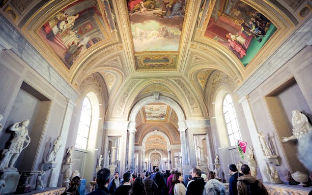 Vatican Museums corridor with ornate ceiling and sculptures, part of Full Rome Pass tour.