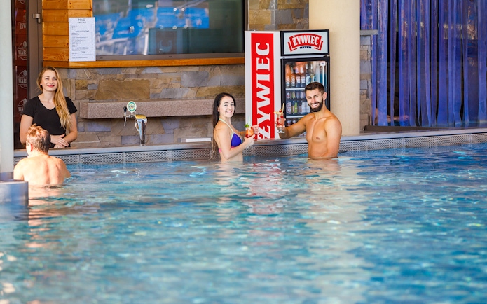 Guests enjoying drinks in the pool at Chocholow Thermal Baths, Poland.