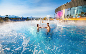 Couple enjoying Chocholow Thermal Baths with mountain view and hotel transfers.