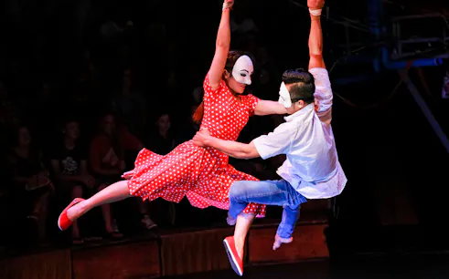 Performers in masks and costumes during an aerial act at Phare, The Cambodian Circus.