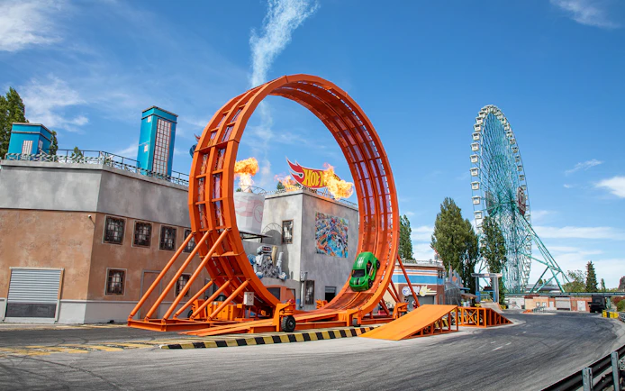Roller coaster loop and Ferris wheel at Mirabilandia theme park, Italy.