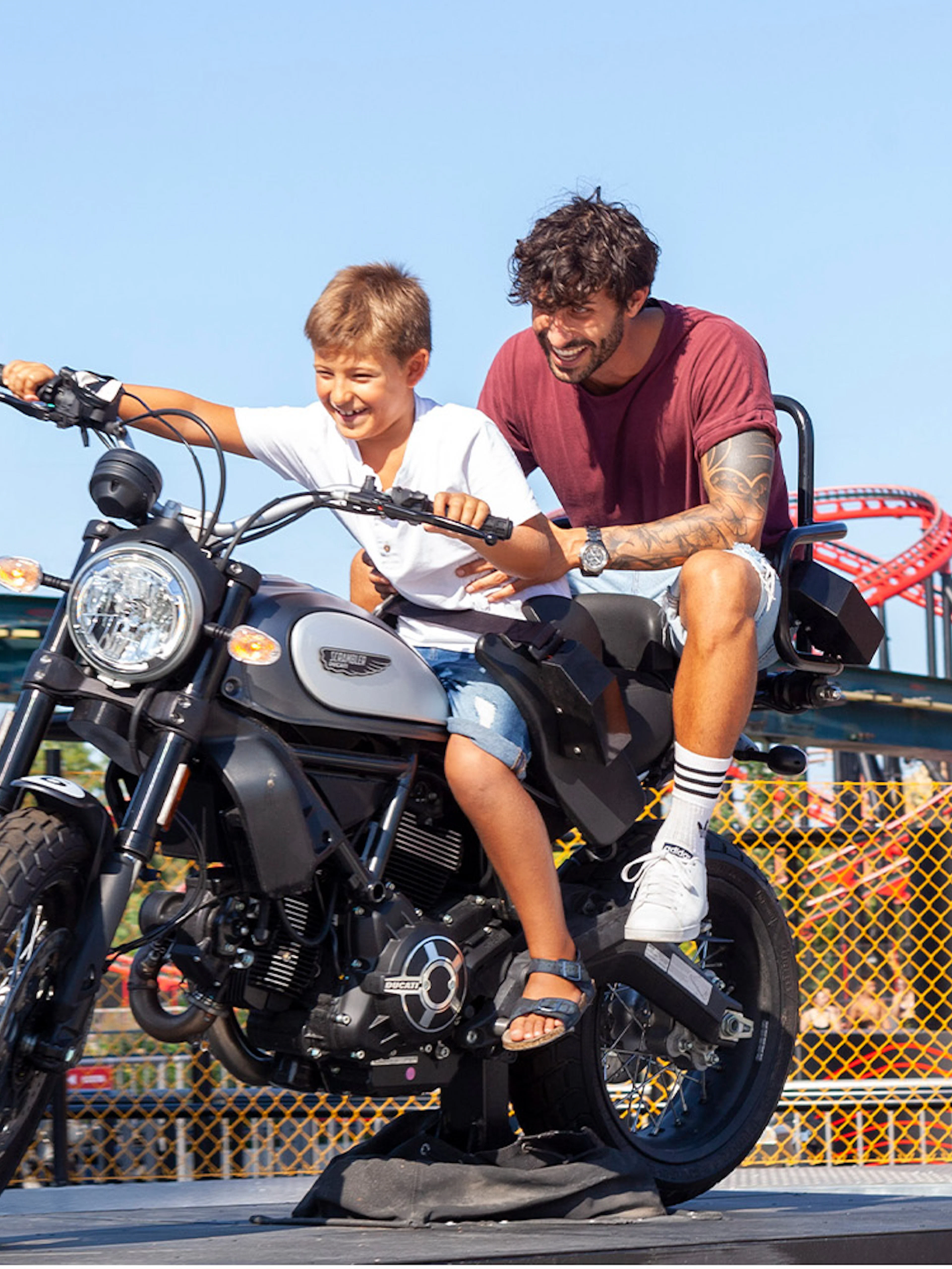 Father and son on a motorcycle ride at Mirabilandia amusement park.