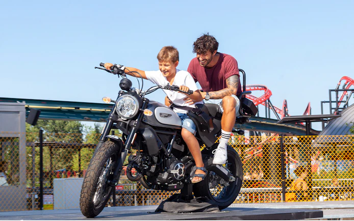 Father and son on a motorcycle ride at Mirabilandia amusement park.