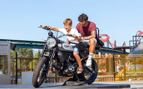 Father and son on a motorcycle ride at Mirabilandia amusement park.