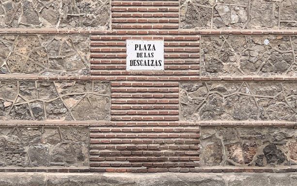 Plaza de las Descalzas sign on stone wall, Madrid.