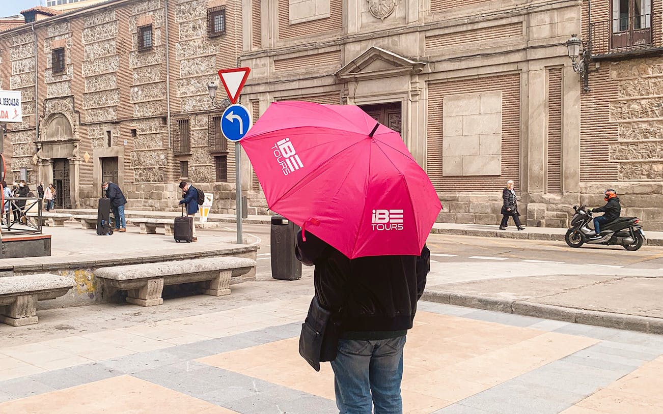 Tour guide with pink umbrella outside Monasterio de las Descalzas, Madrid.