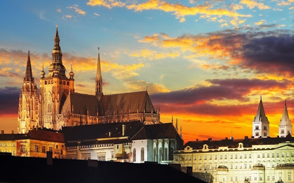 Prague Castle at sunset viewed from the river, part of the eco-friendly cruise experience.