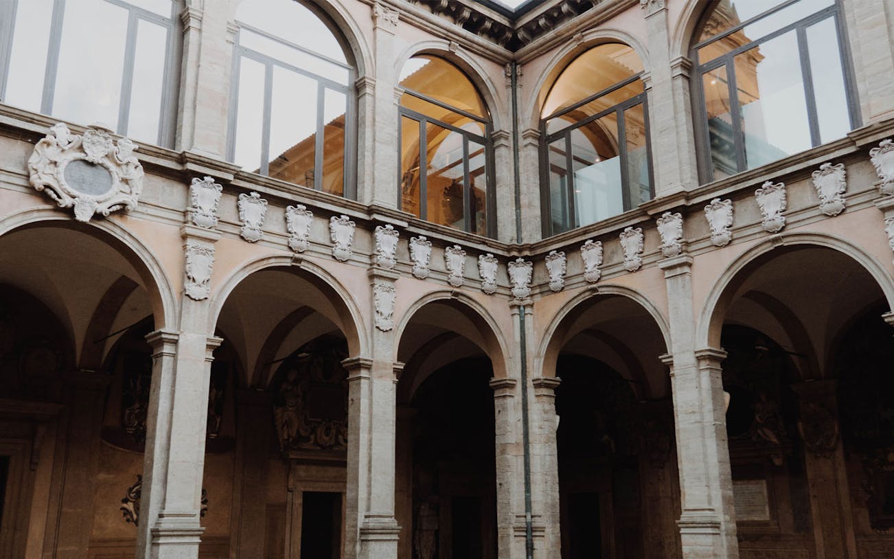 Courtyard arches in historic Bologna building on 2-hour walking tour.