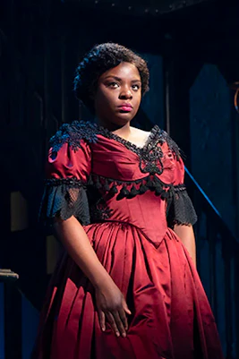 Performer in period costume on stage at Paradise Square.