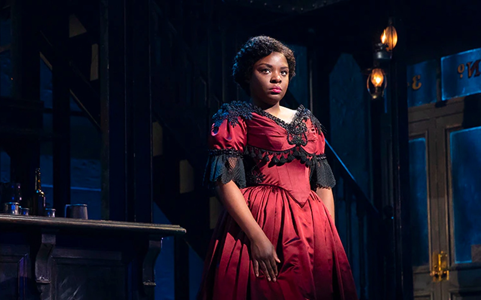 Performer in period costume on stage at Paradise Square.