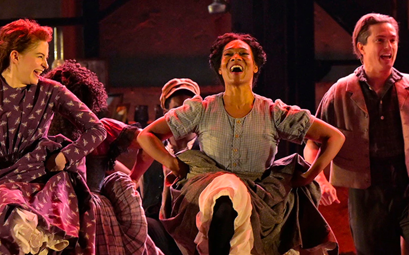 Performers dancing energetically in a lively scene from Paradise Square.