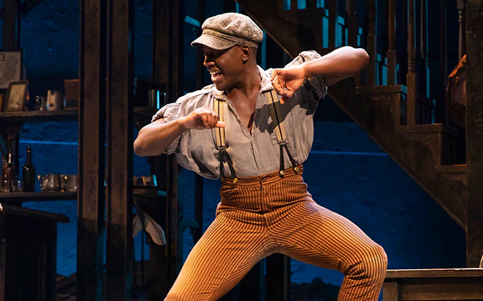 Performer dancing energetically on stage at Paradise Square show.