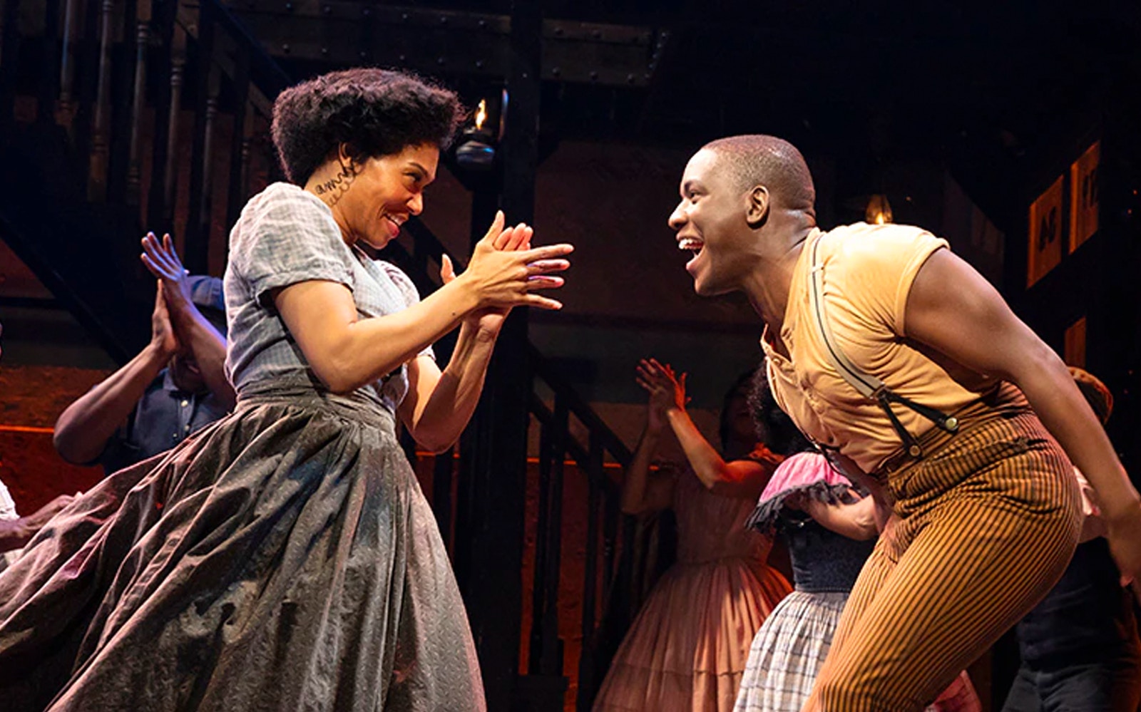 Performers dancing energetically in a scene from Paradise Square musical.