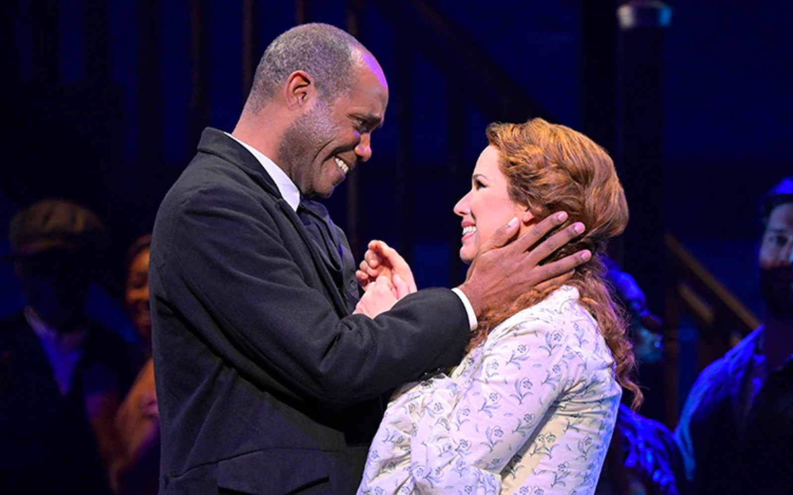 Two actors smiling at each other during a performance of Paradise Square.