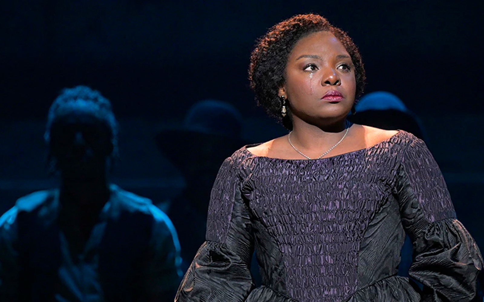 Performer in period costume on stage during Paradise Square show.