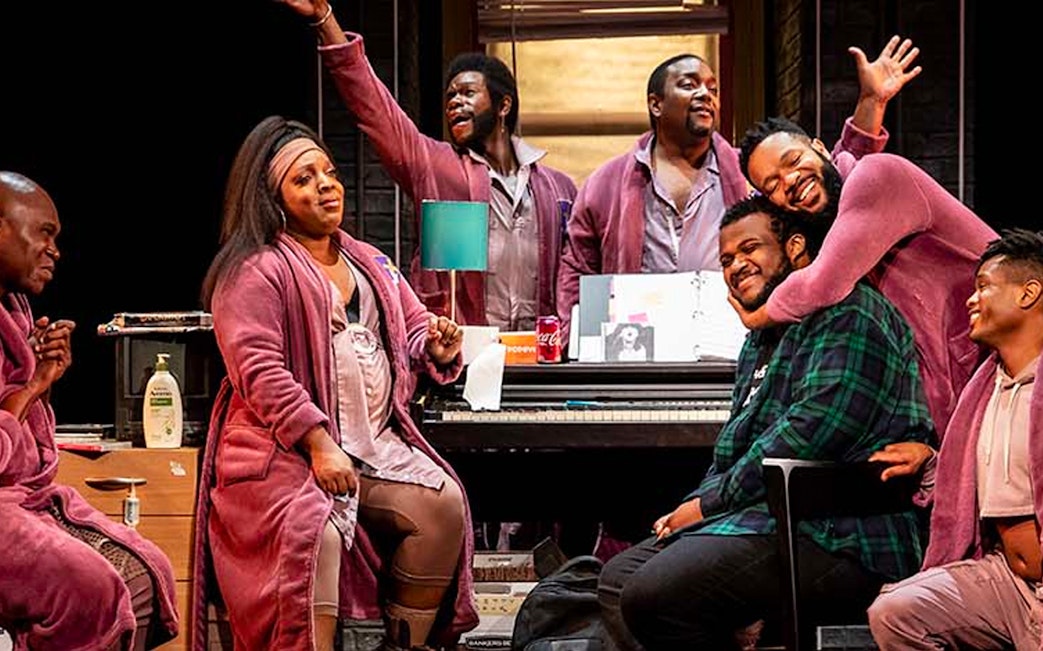 Cast members of "A Strange Loop" performing on stage in a lively scene.