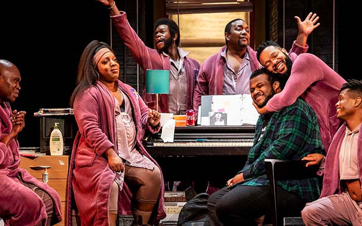 Cast members of "A Strange Loop" performing on stage in a lively scene.