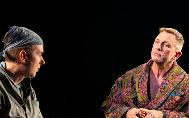 Two actors in a dramatic scene from Macbeth on stage.