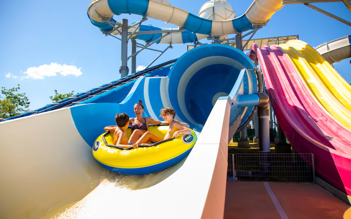 Family enjoying a water slide ride at Mirabeach water park.
