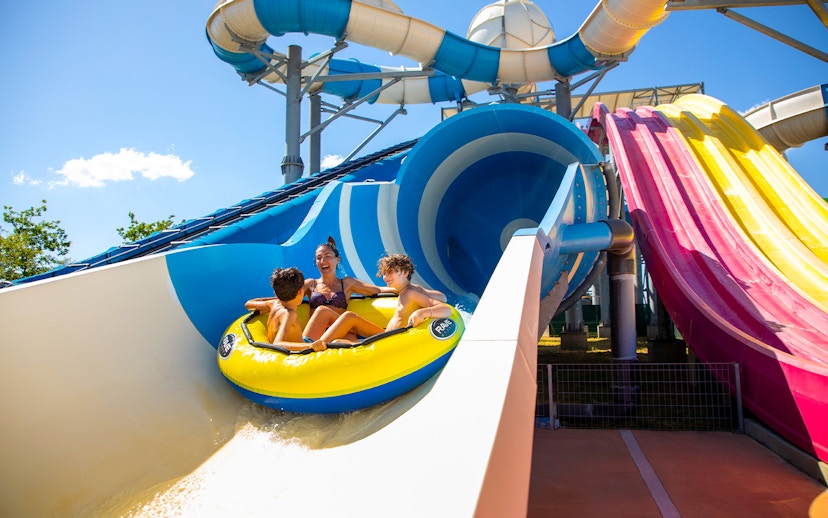 Family enjoying a water slide ride at Mirabeach water park.