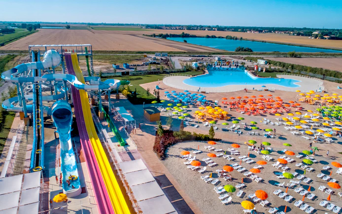 Water slides and colorful umbrellas at Mirabeach water park, Italy.