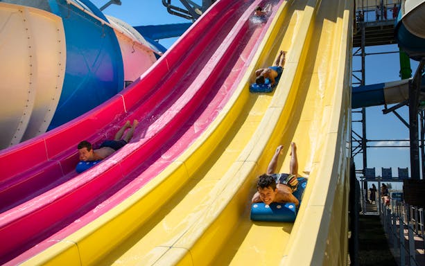 Visitors enjoying colorful water slides at Mirabeach.