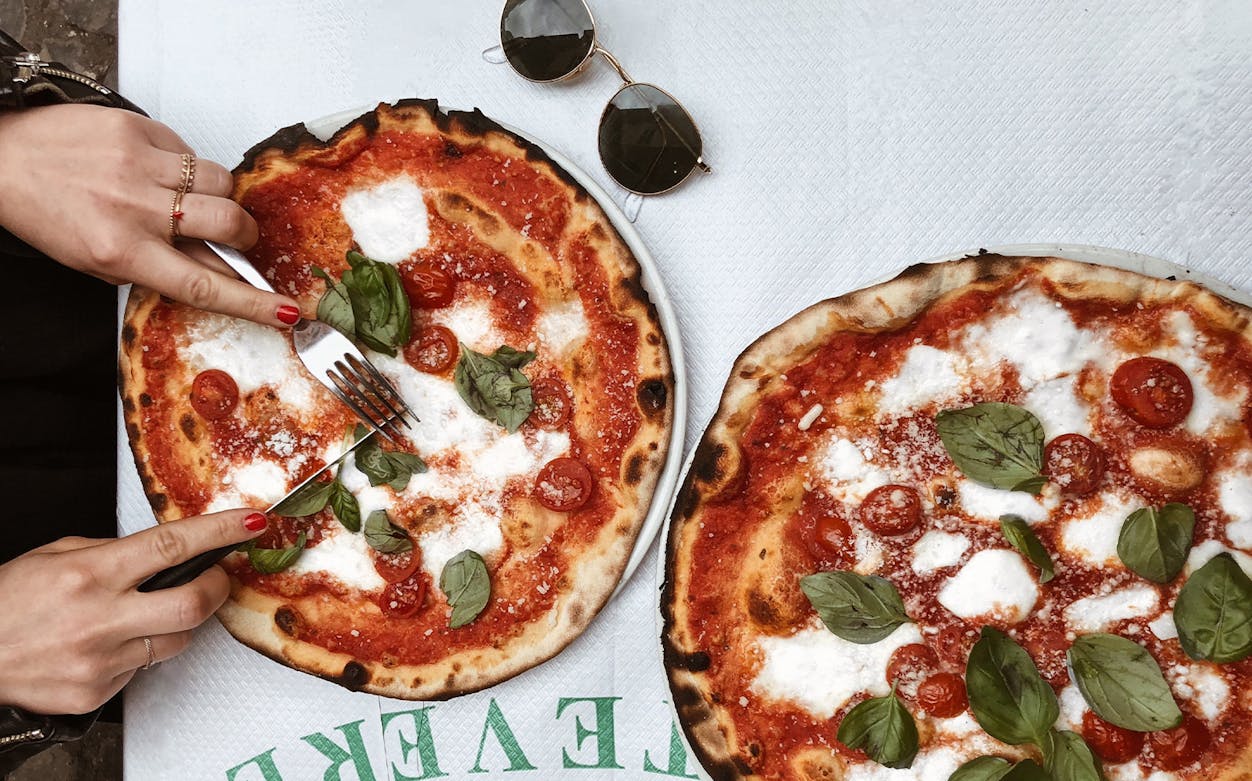 Pizza with fresh basil and tomatoes at a Testaccio Rome eatery during an audio walking tour.