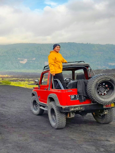 Two people on red jeeps during Bali Mount Batur sunrise tour.