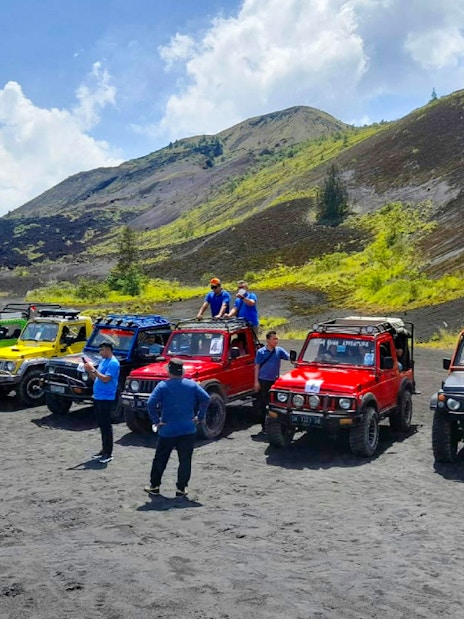 Colorful jeeps lined up for Bali Mount Batur sunrise tour with participants preparing.
