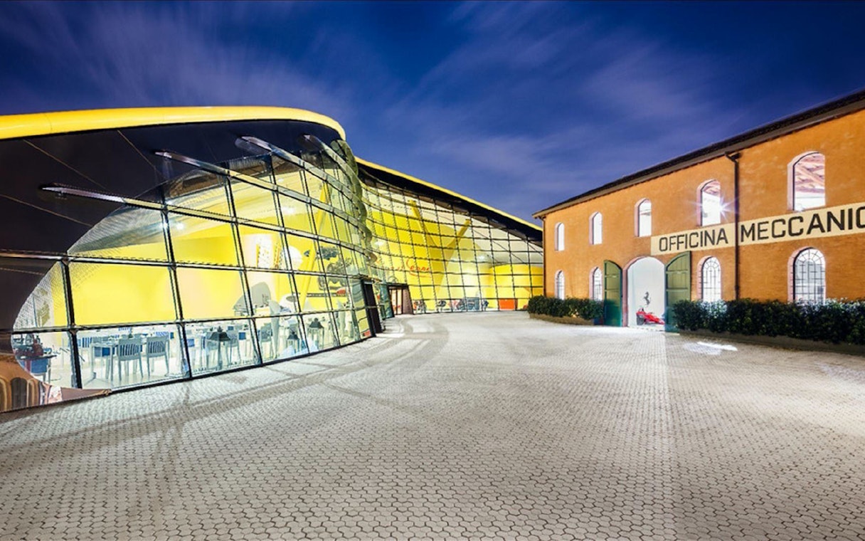 Museo Enzo Ferrari Modena entrance with modern glass facade and historic building.