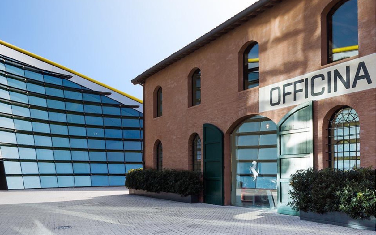 Museo Enzo Ferrari Modena entrance with modern glass building and historic brick structure.