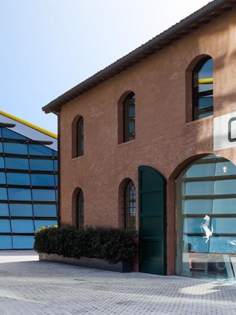 Museo Enzo Ferrari Modena entrance with modern glass building and historic brick structure.