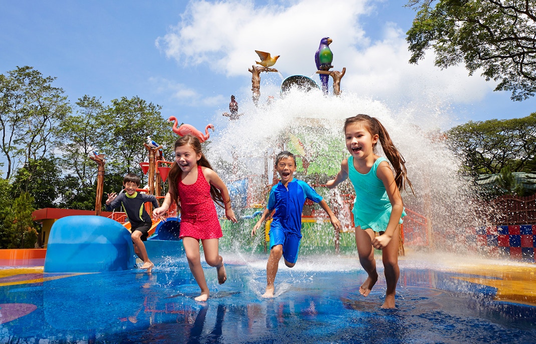 Children playing in water at Jurong Bird Park's splash zone, Singapore.