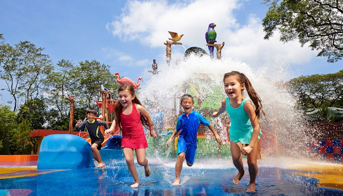 Children playing in water at Jurong Bird Park's splash zone, Singapore.