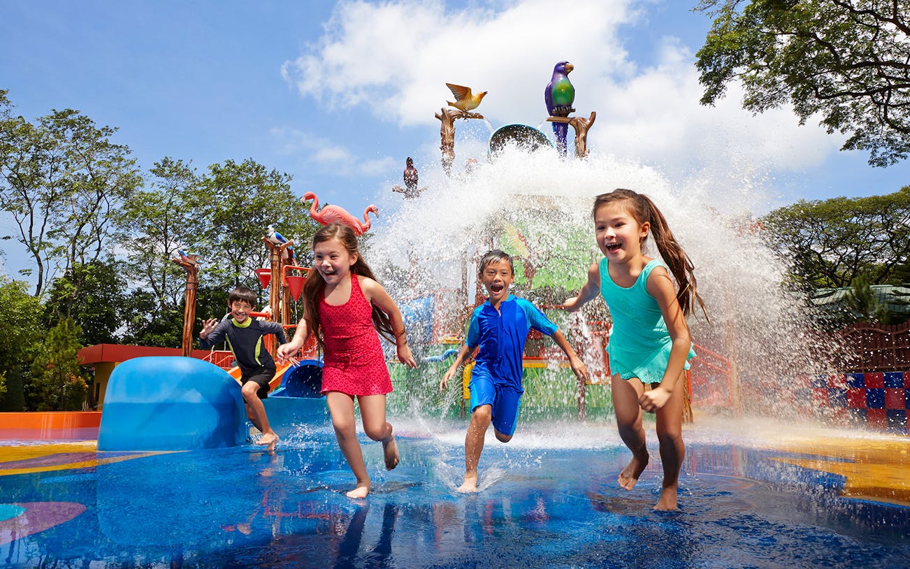 Children playing in water at Jurong Bird Park's splash zone, Singapore.