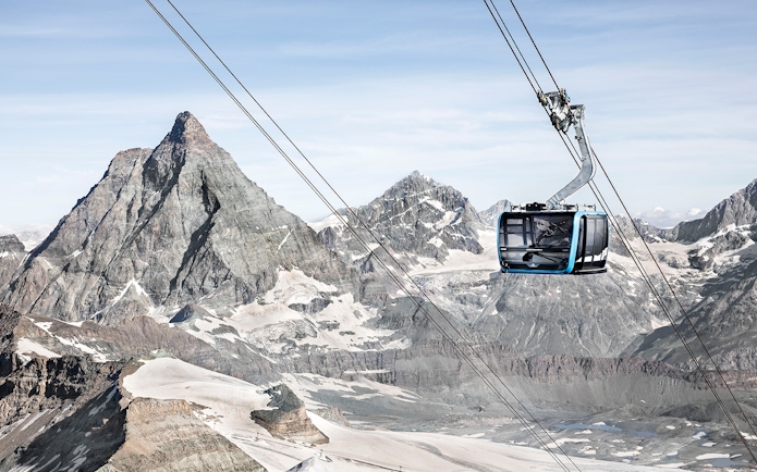 Zermatt cable car ascending towards Matterhorn Glacier Paradise with snow-covered peaks.