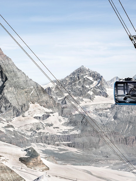 Zermatt cable car ascending towards Matterhorn Glacier Paradise with snow-covered peaks.